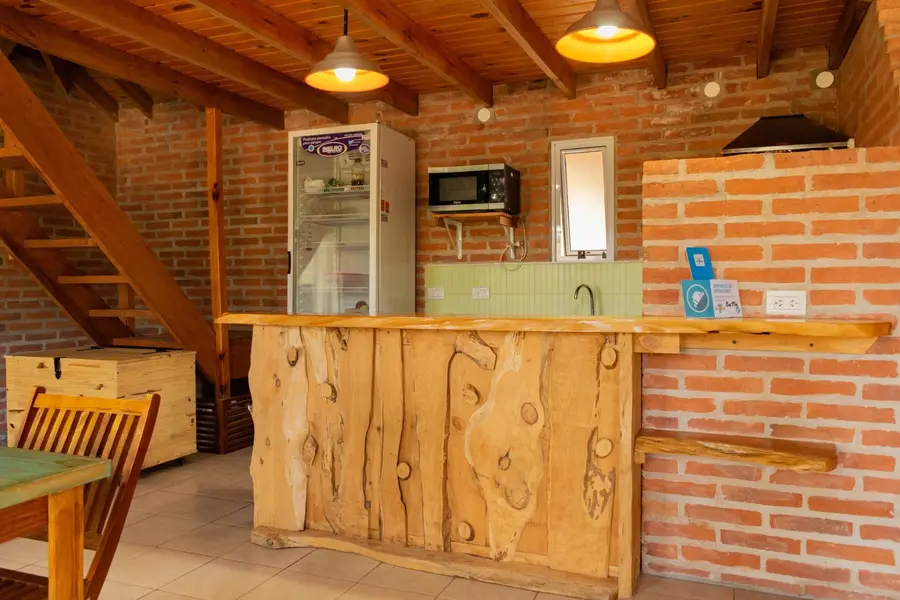 Cocina con barra de madera, heladera y microondas