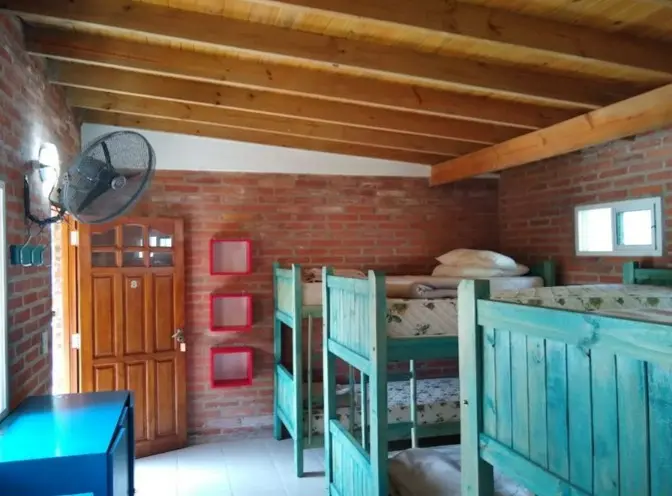 Habitación con ventilador, estantes rojos y camas marineras