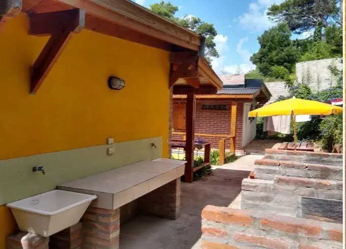 Pileta de lavar bajo el alero amarillo, junto al patio